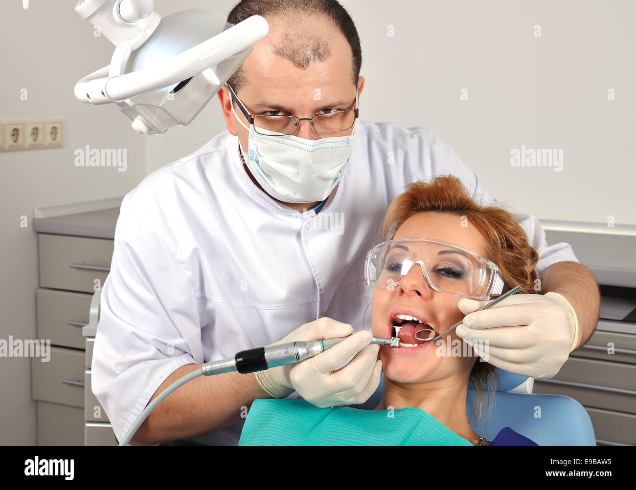 dentist treats teeth of a beautiful girl Stock Photo