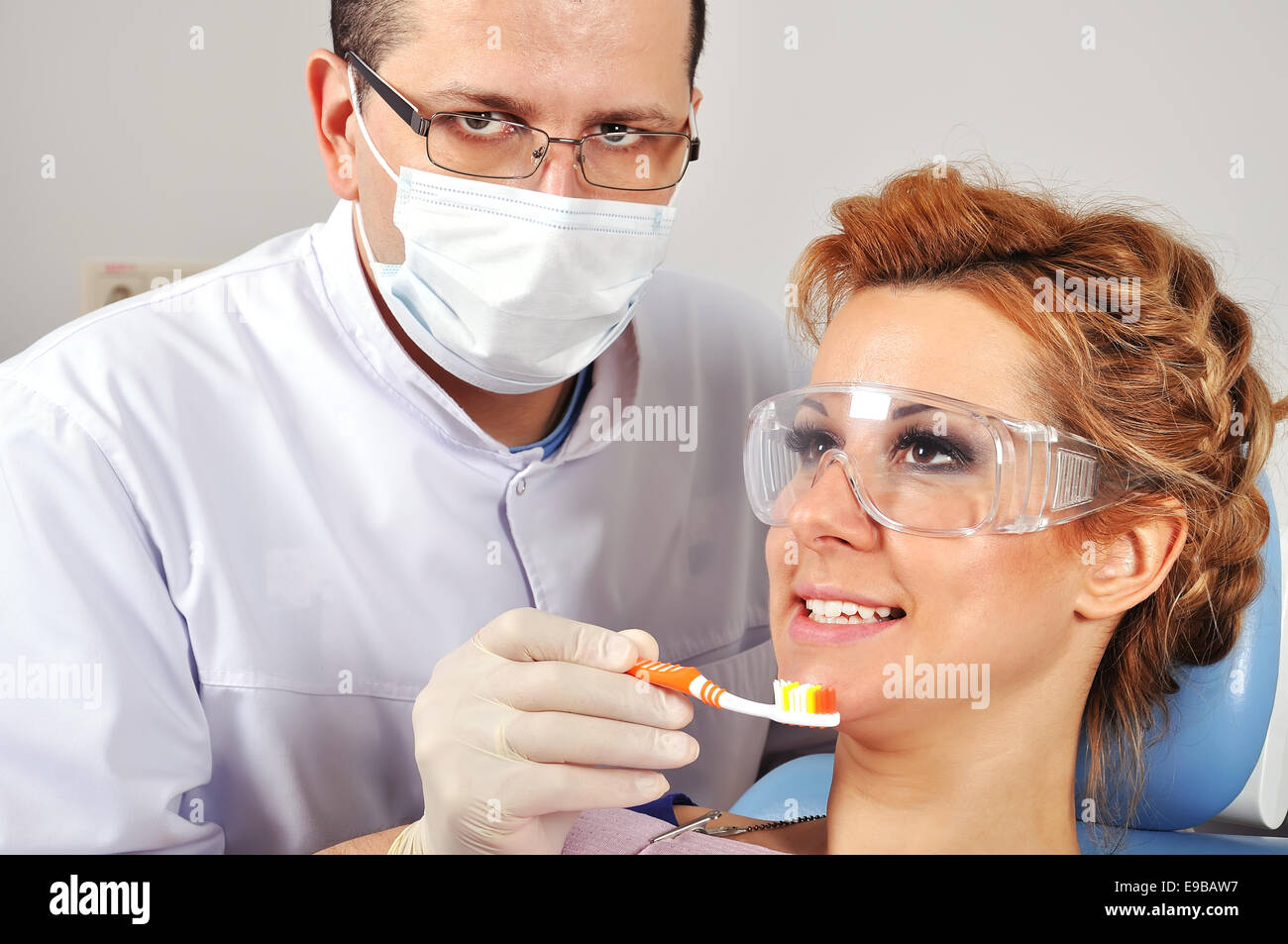 Dentist shows a patient how to brush teeth Stock Photo Alamy