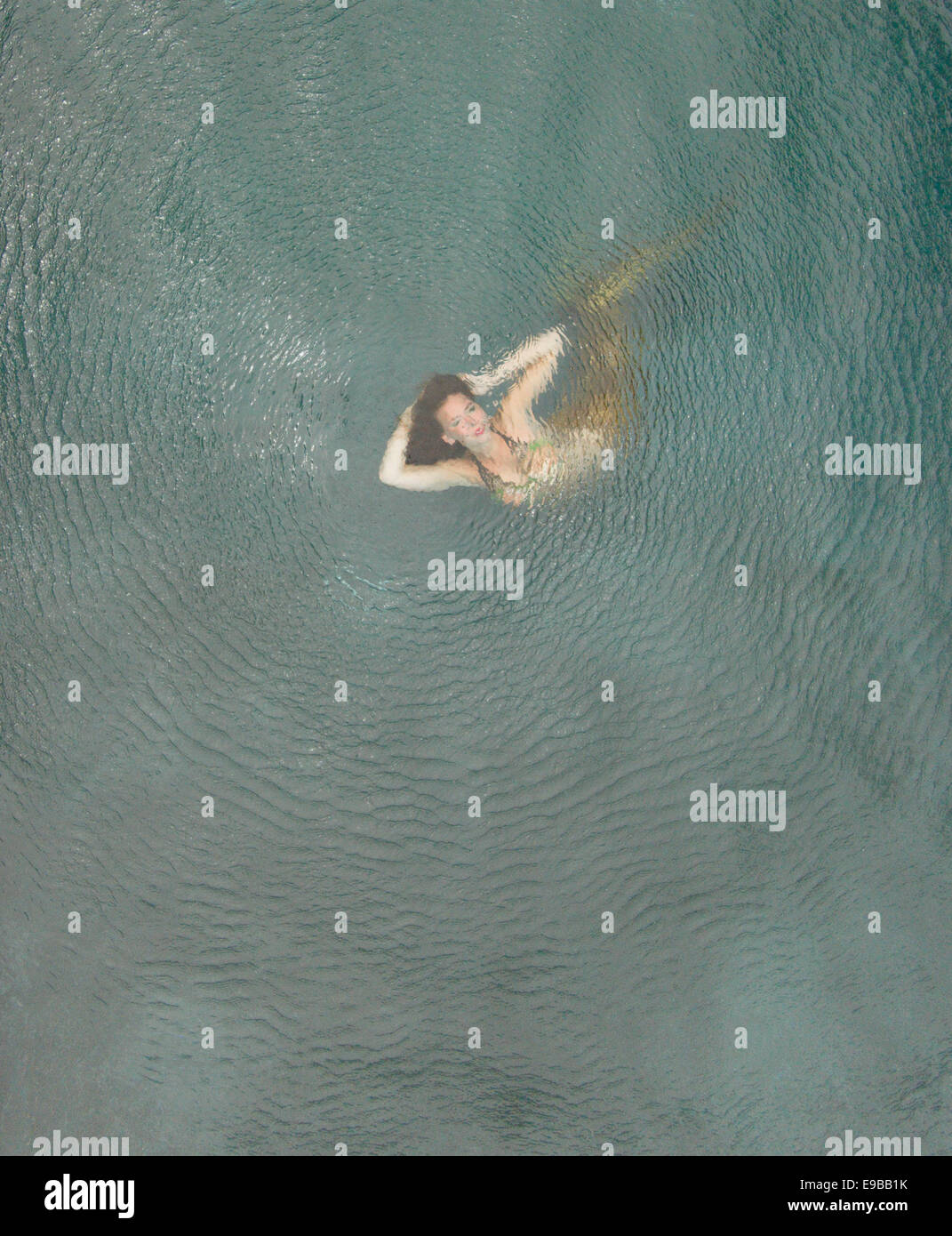 Aerial photo of a mermaid in a swimming pool with ripples from drone's props Stock Photo