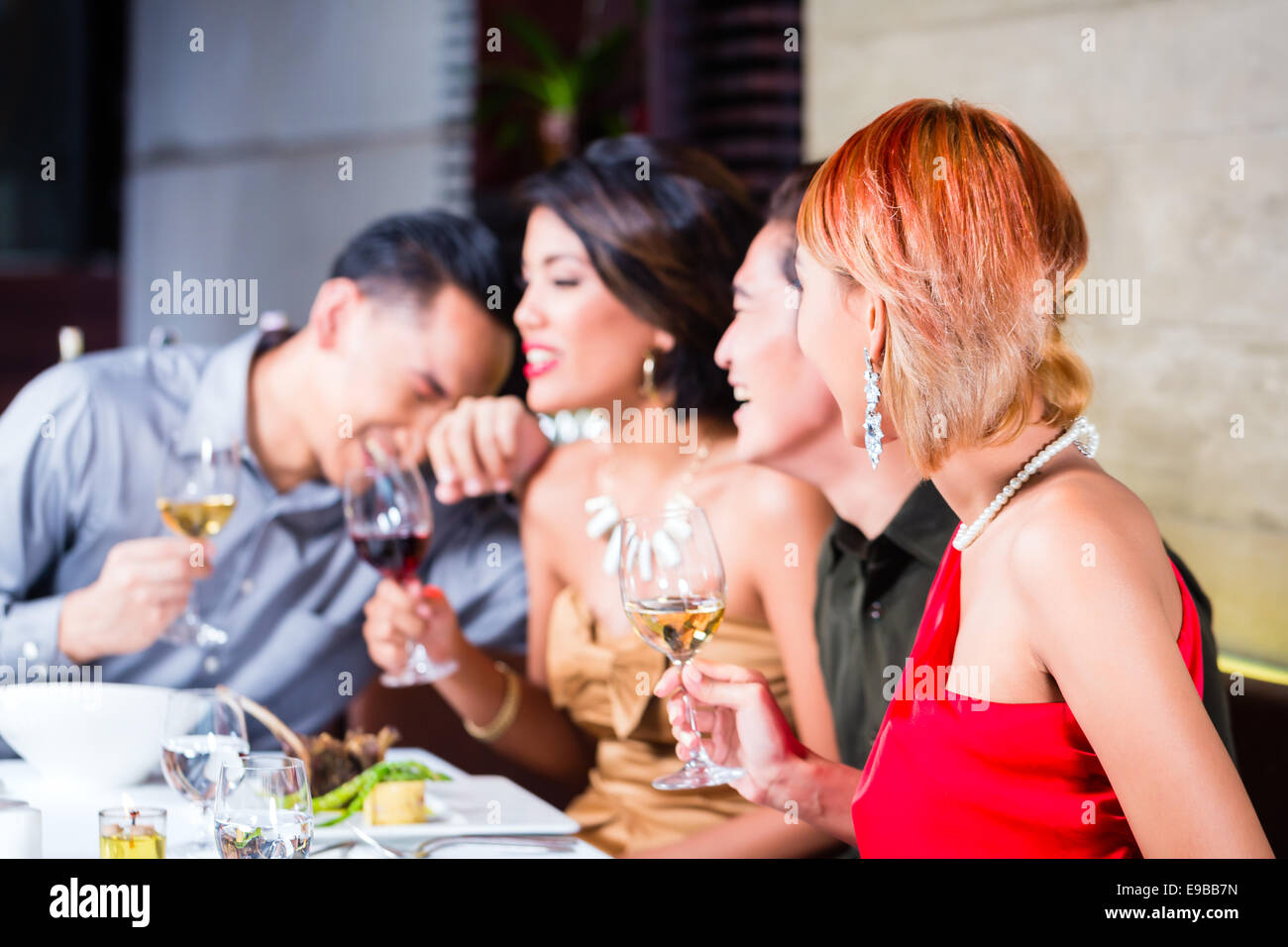 Asian friends, two couples, dining in fancy restaurant eating good food