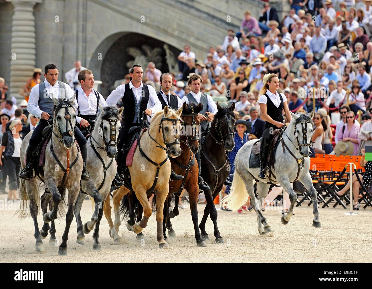 An equestrian team canter into an arena to give a display of stunt riding and horsemanship Stock Photo