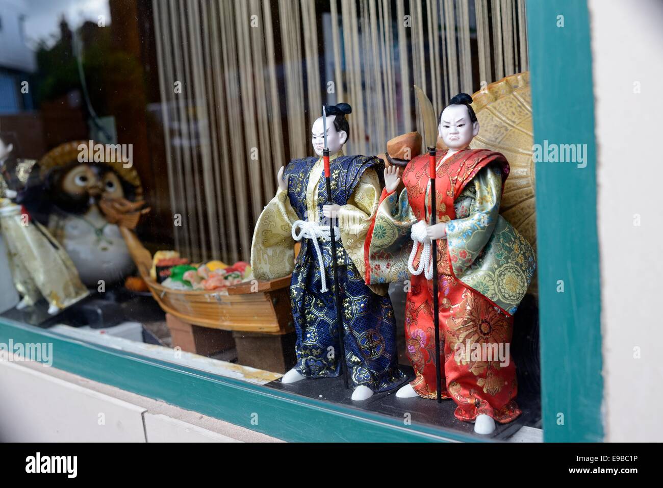 Two Japanese Samurai warrior dolls in the window of a city suchi bar