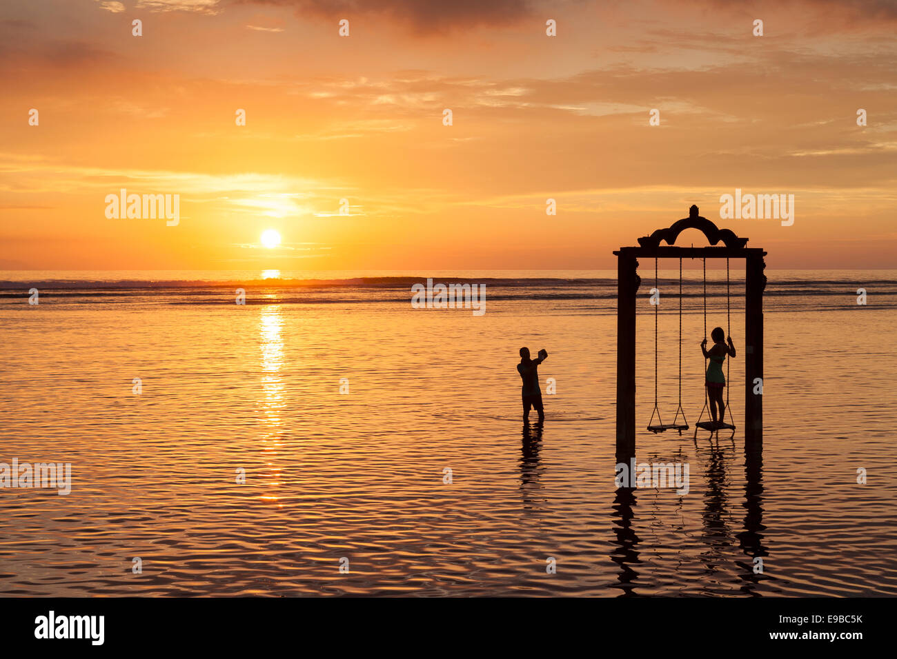 Romantic couple and sea swing at sunset, 'Gili Trawangan', 'Gili Islands', Indonesia Stock Photo