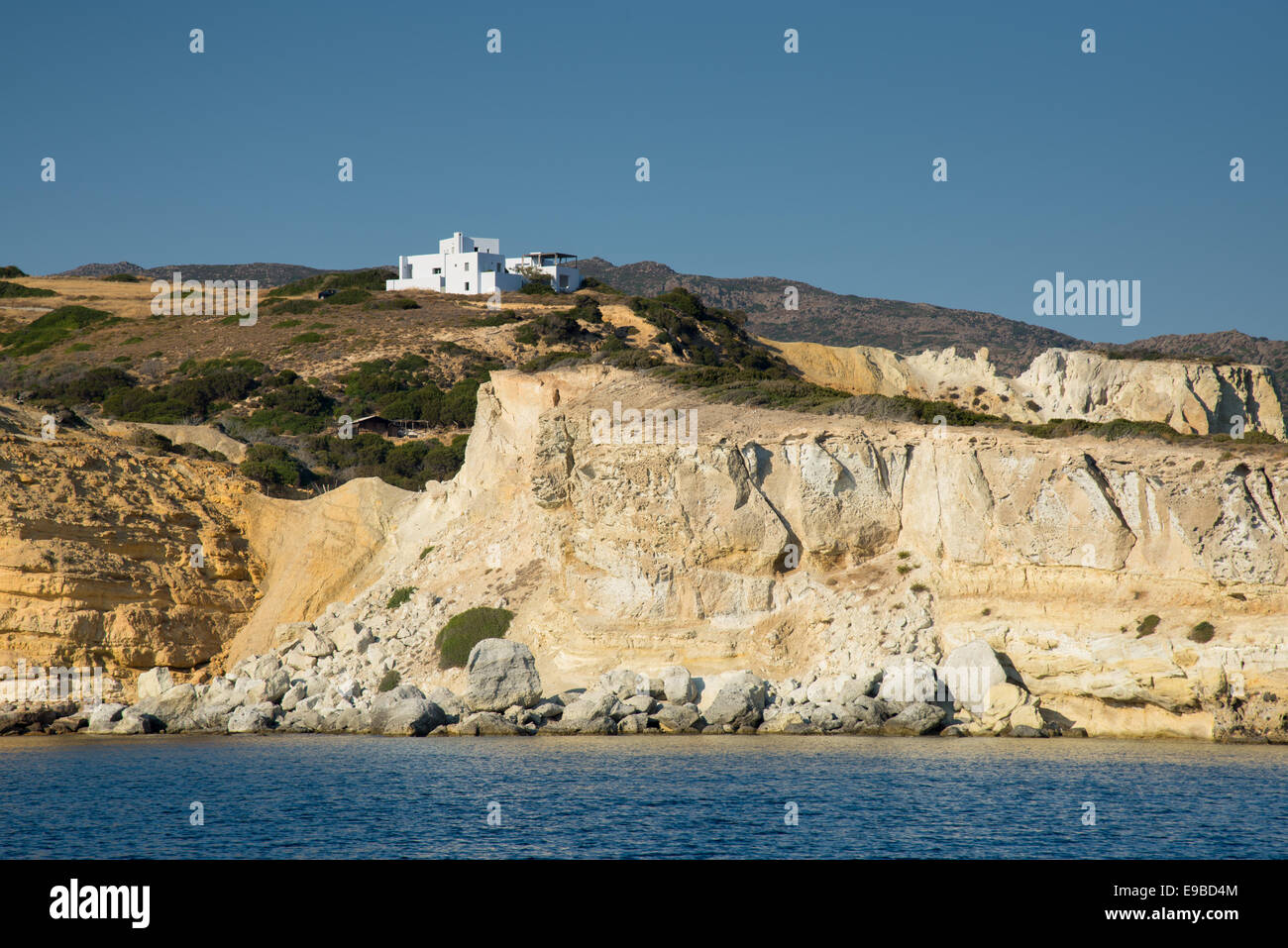 house on top of cliffs at milos island in greece Stock Photo