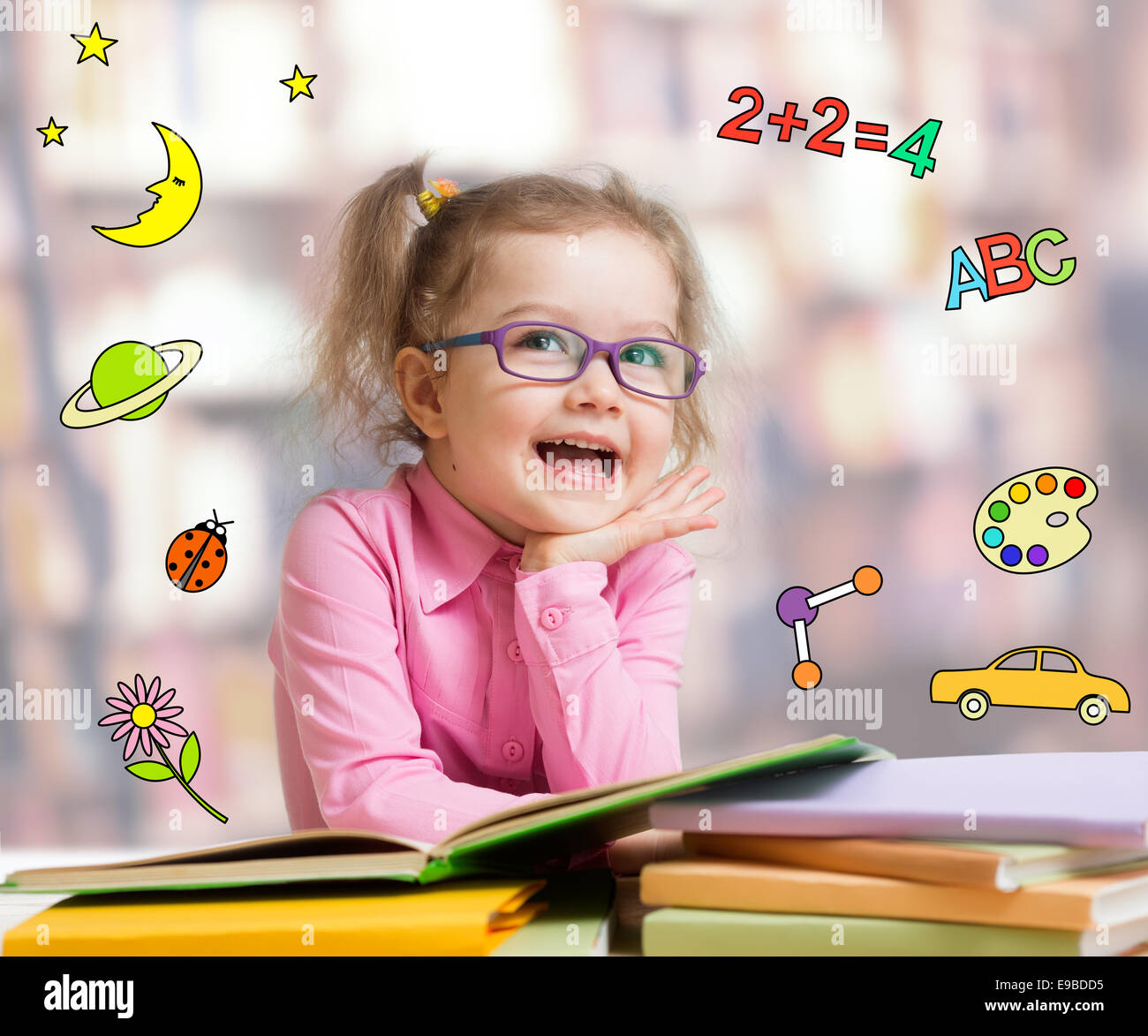 Funny smart kid in glasses reading book Stock Photo