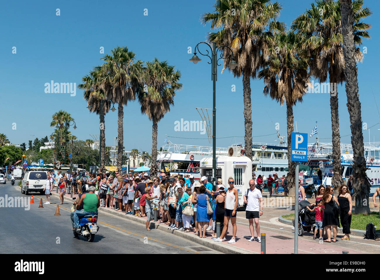Tourists waiting for transport, Town of Kos, island of Kos, Greece Stock Photo