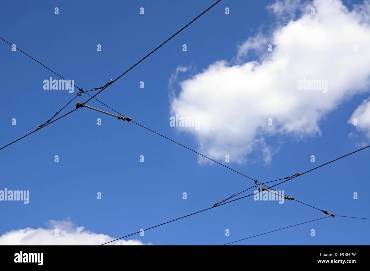 Modern overhead power line cables for trams against a blue sky Stock