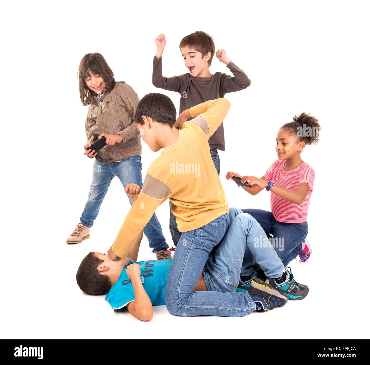 Boys fighting with other kids cheering and filming Stock Photo