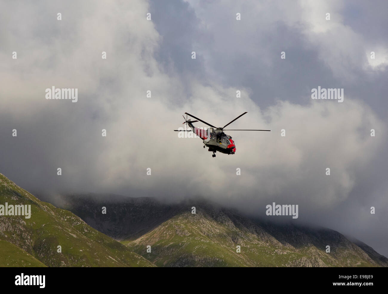Royal Navy rescue helicopter operating above the slopes of Glen Nevis near Ben Nevis, Scotland Stock Photo