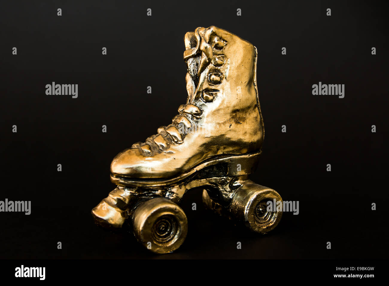 golden roller skate with high heel isolated against black background Stock Photo Alamy