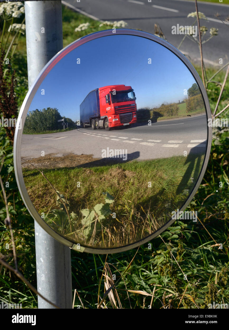 lorry passing warning sign of sharp bend and circular safety mirror to