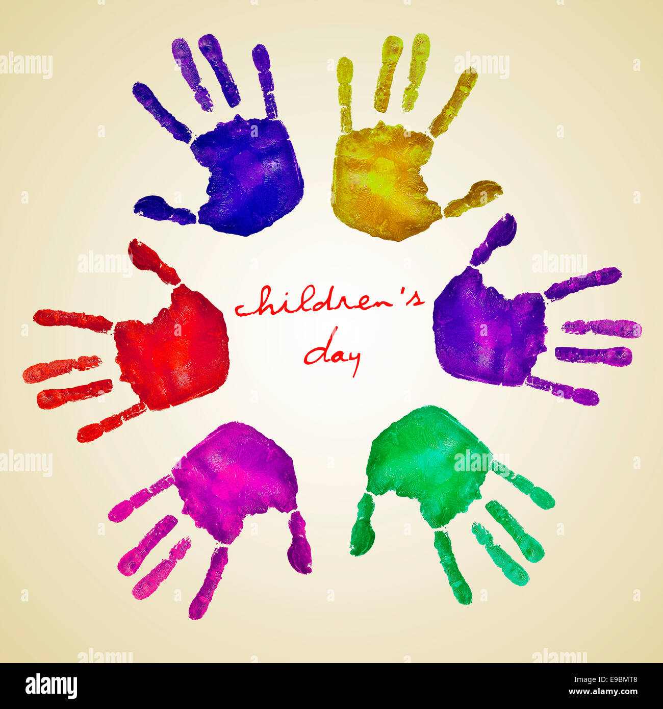 handprints of different colors forming a circle and the text childrens day written in the center on a beige background Stock Photo