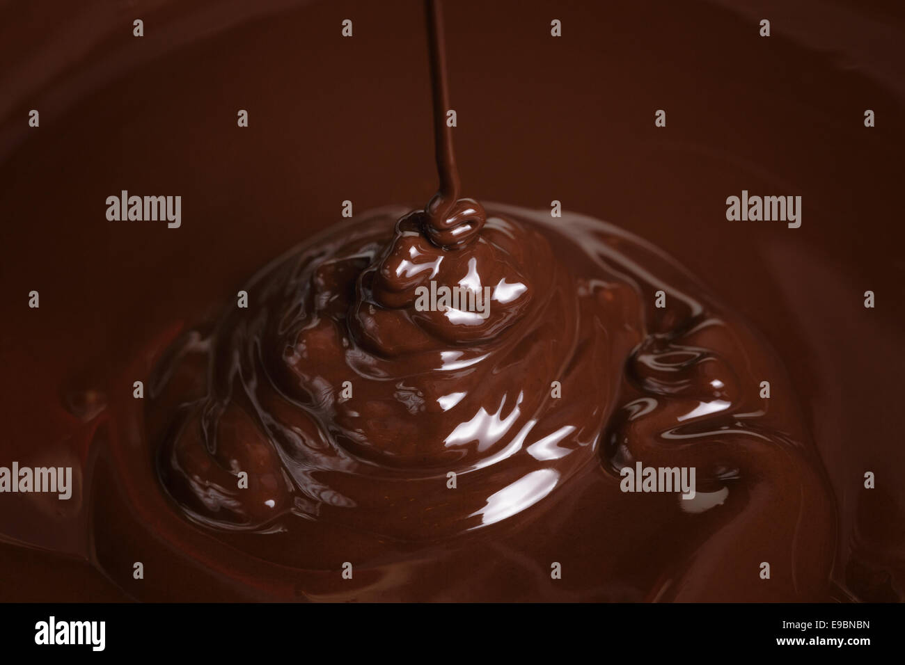 melted dark chocolate flow, candy or chocolate preparation background Stock Photo