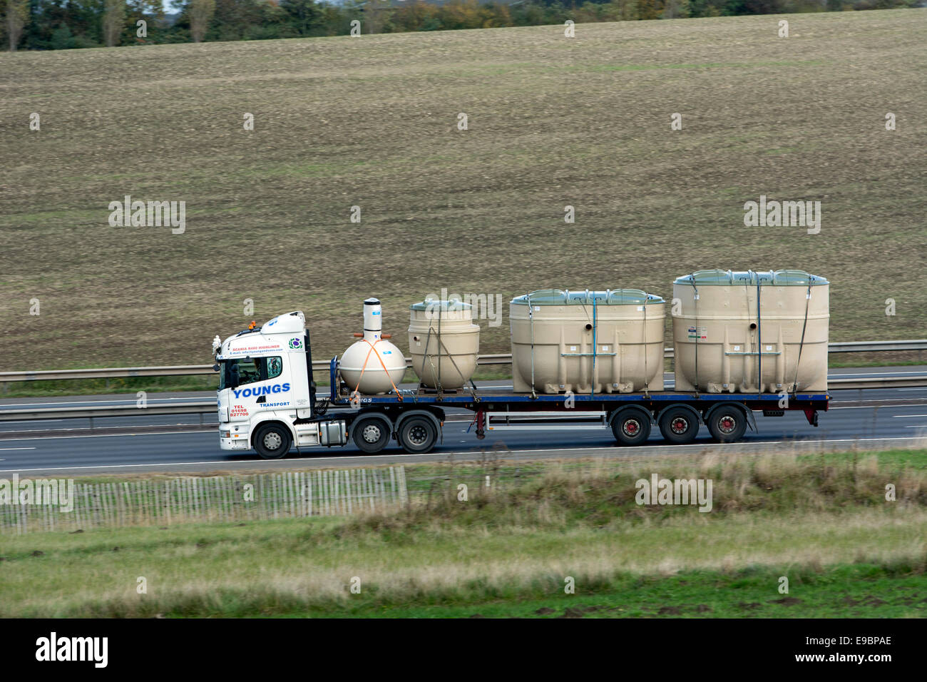 Lorry carrying cesspit tanks on M40 motorway, Warwickshire, UK Stock Photo