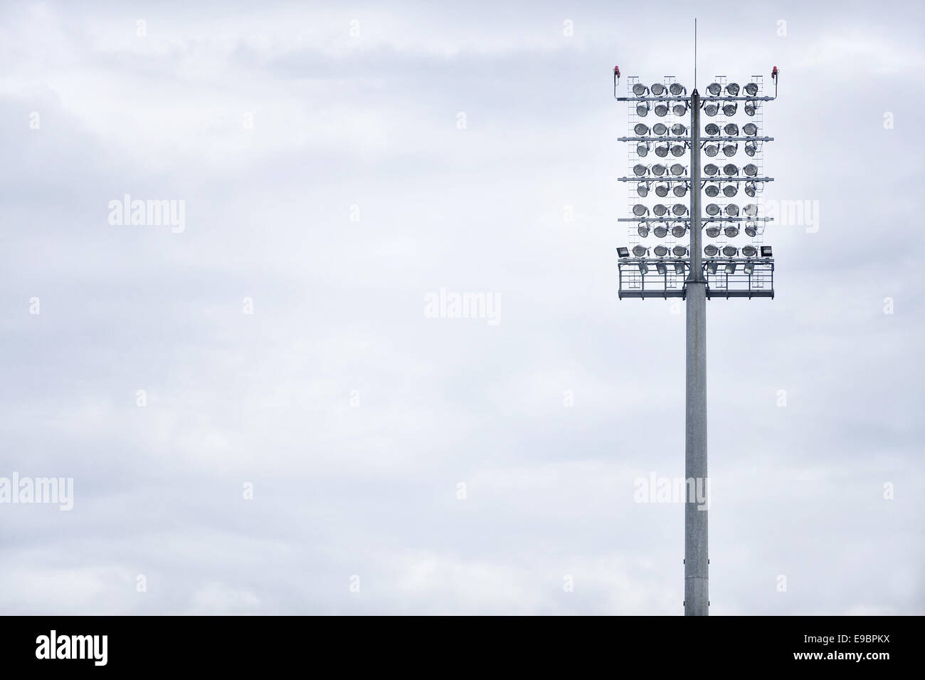 Sports arena floodlights isolated with overcast sky on background Stock Photo