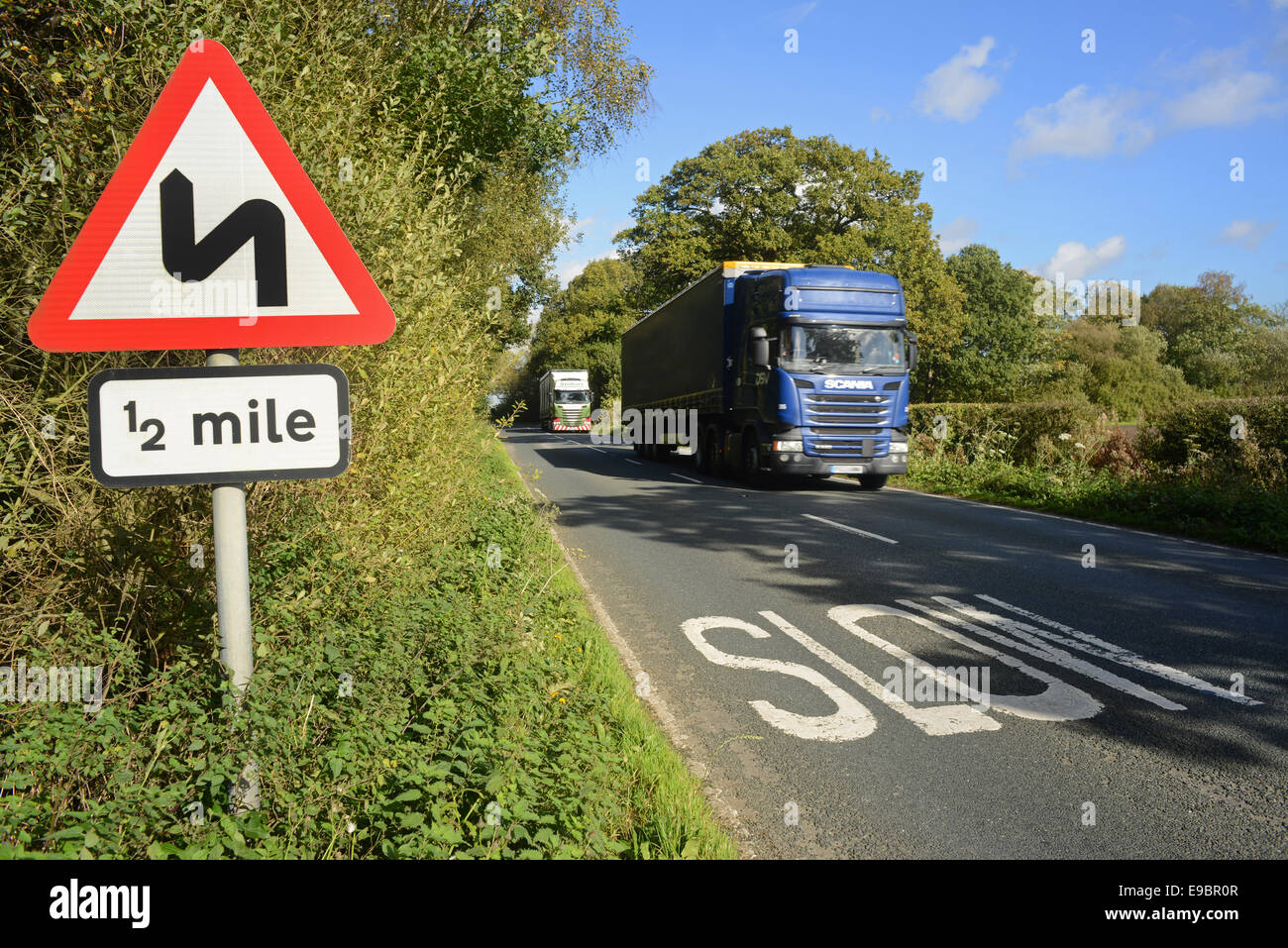 lorry passing sharp bend warning sign for half a mile ahead yorkshire united kingdom Stock Photo
