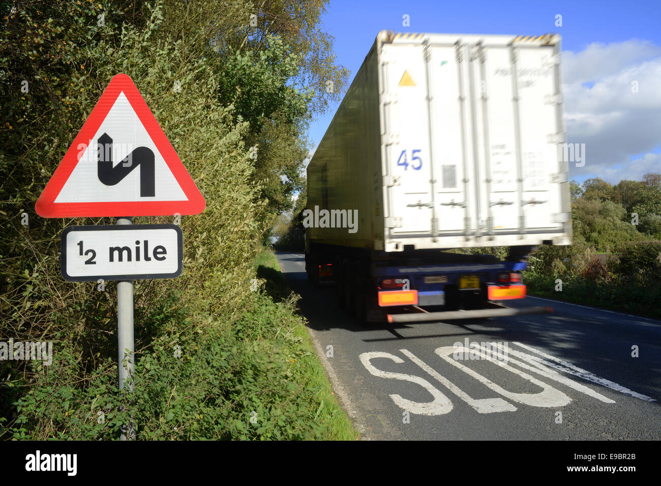 lorry passing sharp bend warning sign for half a mile ahead yorkshire united kingdom Stock Photo