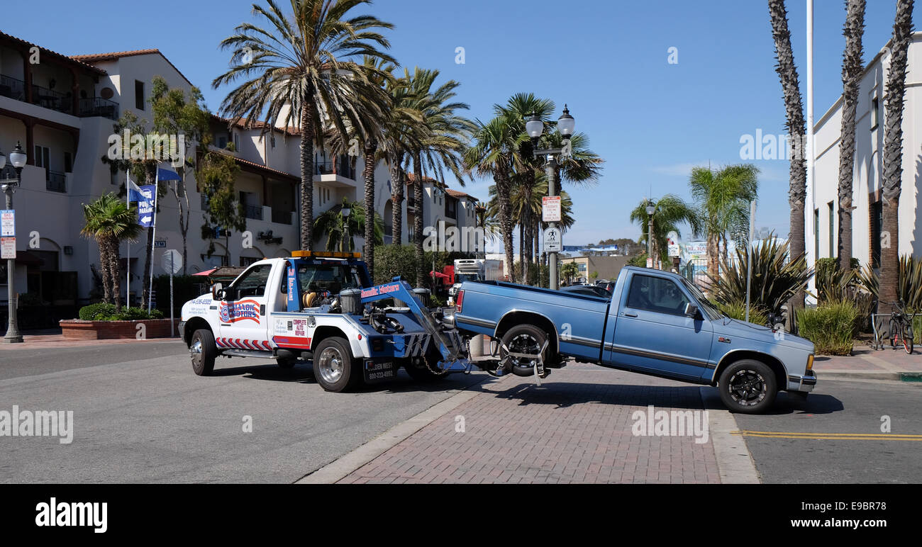 A tow truck tows a pickup at Huntington beach surf city Stock Photo