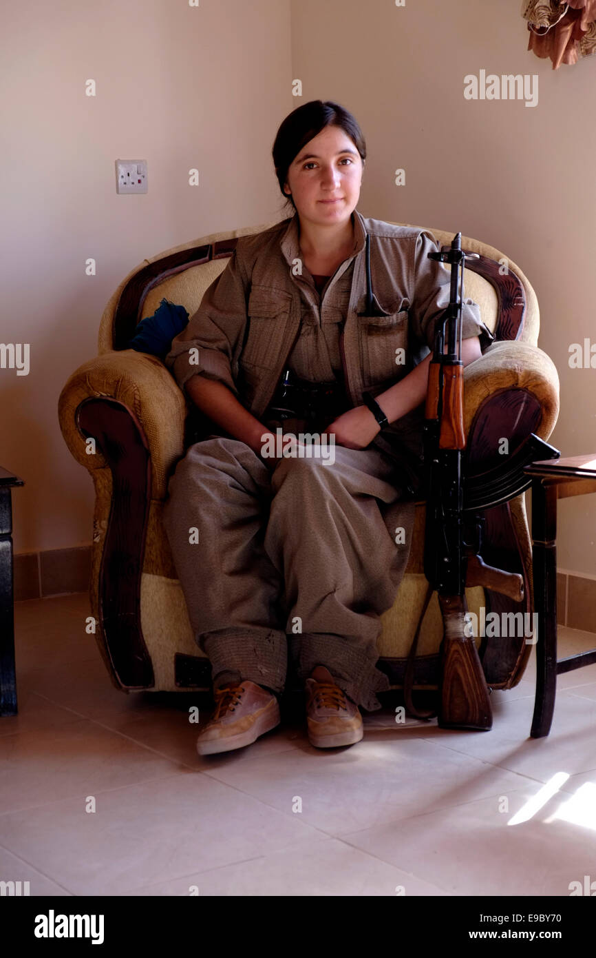 A young female Kurdish fighter of the Free Women's Units shortened as YJA STAR the women's military wing of the Kurdistan Workers' Party PKK sitting with a Kalashnikov ak-47 gun in the village of Makhmur near Mosul in Iraq Stock Photo