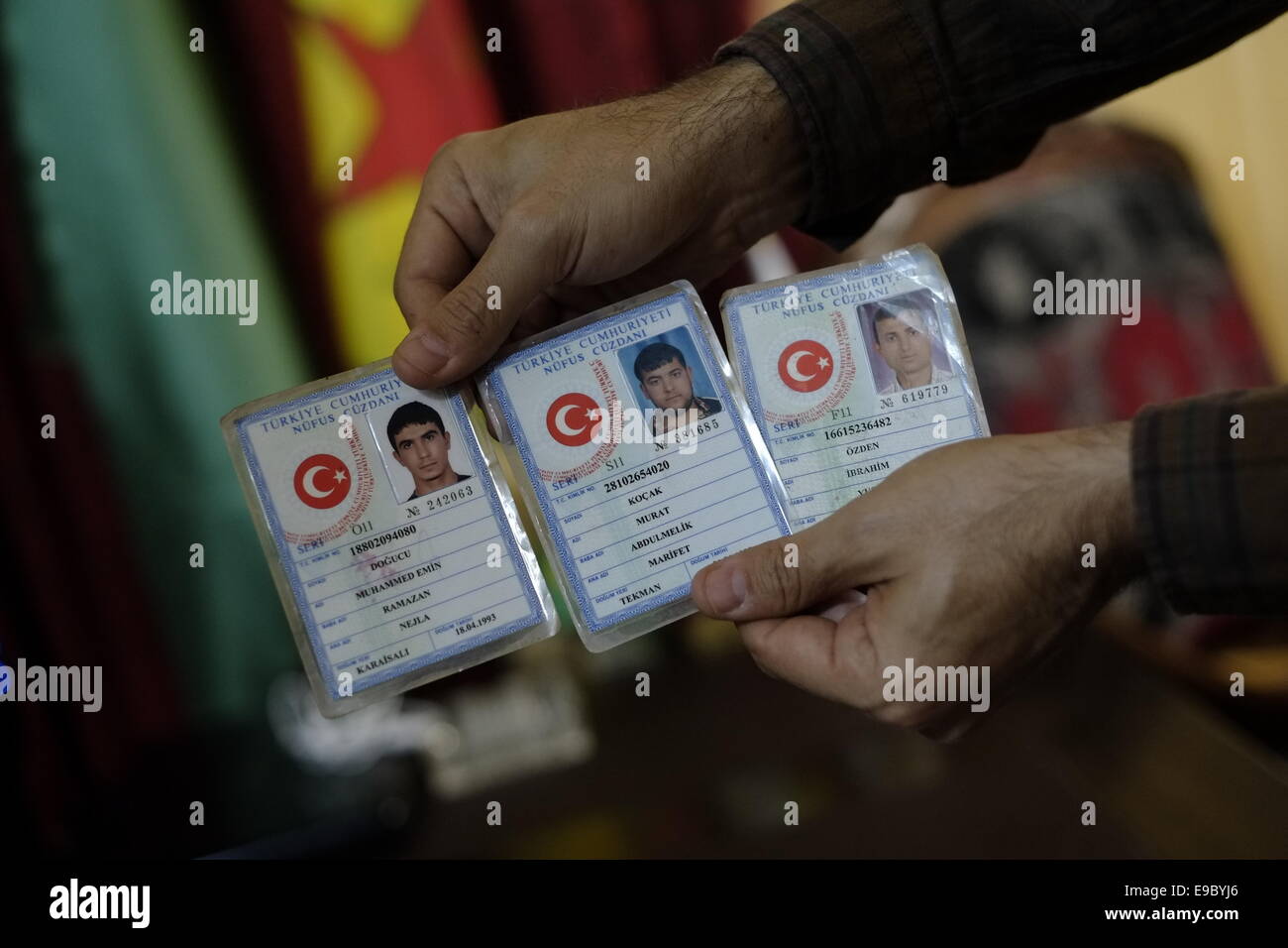 A fighter of the Kurdish People's Protection Units YPG holds collection of Turkish identity cards of captured ISIS ISIL or Daesh militants in the city of Qamishli or Qamishlo in Al Hasakah or Hassakeh district in northern Syria Stock Photo