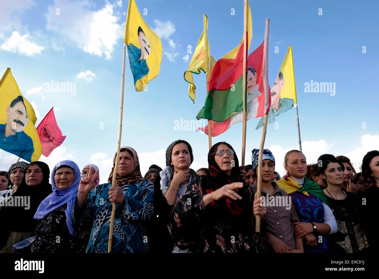 Kurdish women holding flags with the figure of Abdullah Ocalan founding member of the militant organization the Kurdistan Workers' Party or PKK at a rally in support of Syrian Kurds suffering from ISIS attacks in the Syrian city of  Kobane in the city of Erbil also spelled Arbil or Irbil the capital city of Kurdistan Region in northern Iraq. Stock Photo