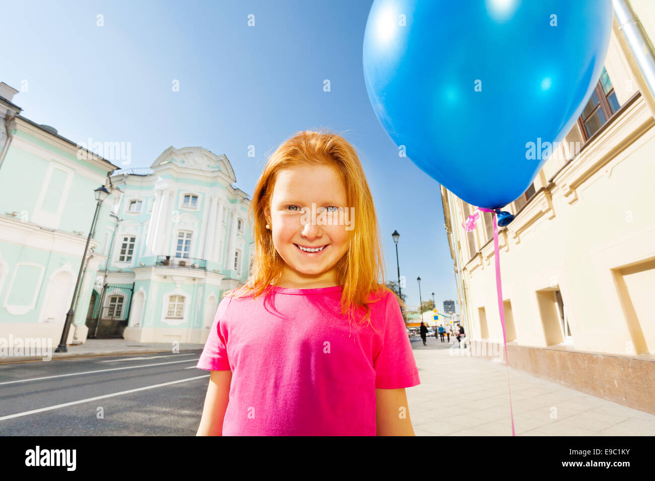 Smiling girl with flying balloon stands on street Stock Photo Alamy