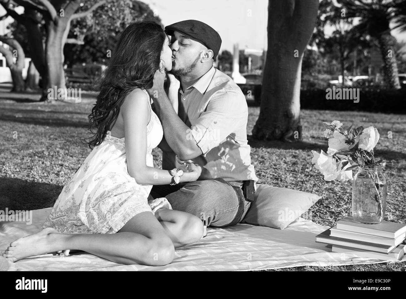 couple kissing in park during a picnic in black and white Stock Photo