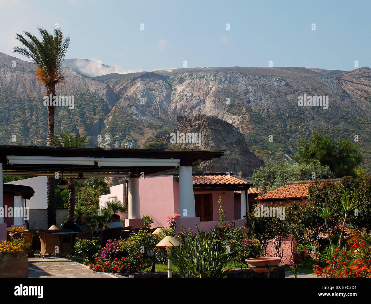 Aeolian architecture in palm garden with a view of the smoking volcano craters Gran Cratere - June 2014 Stock Photo