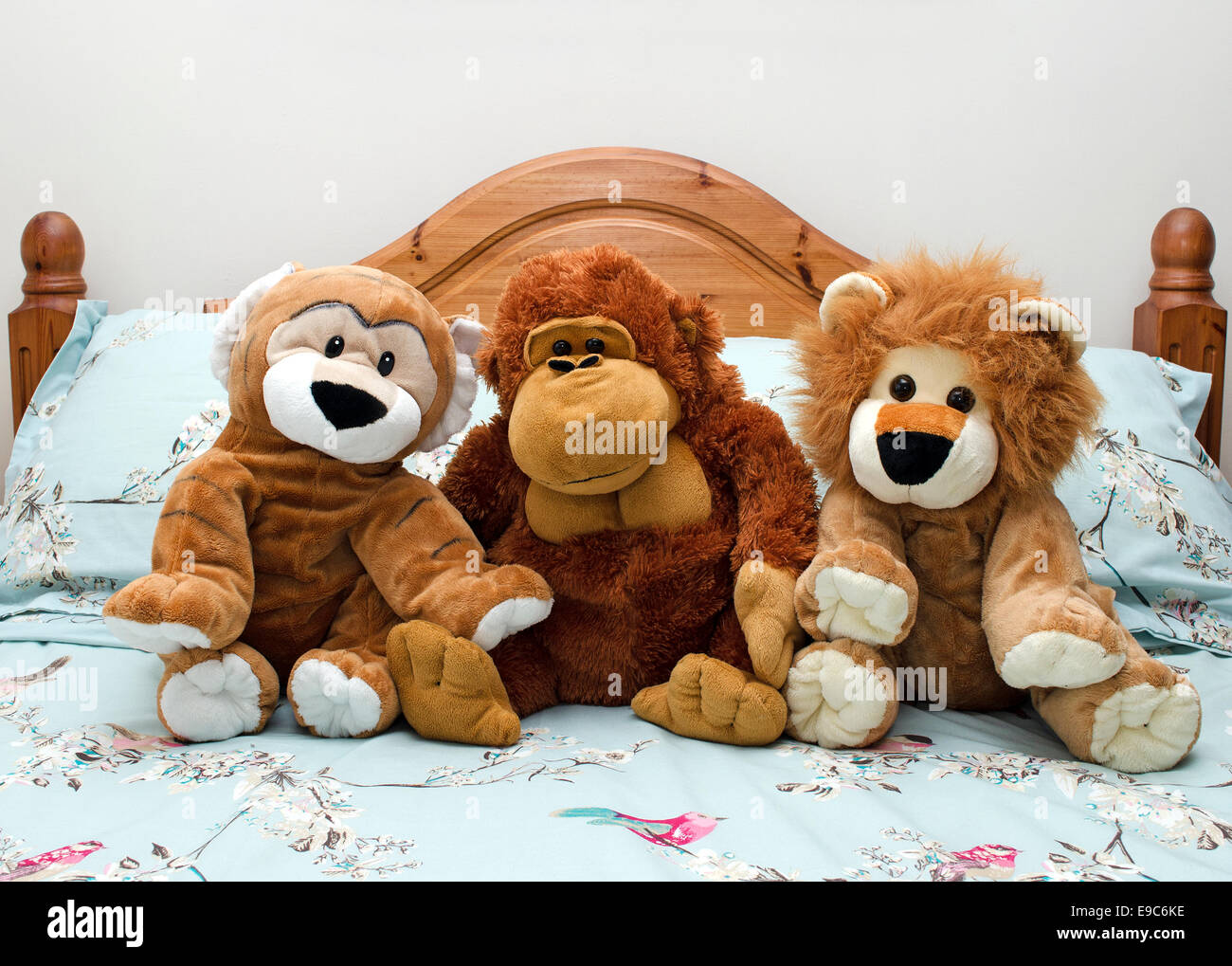 cuddly toys sitting on a bed Stock Photo