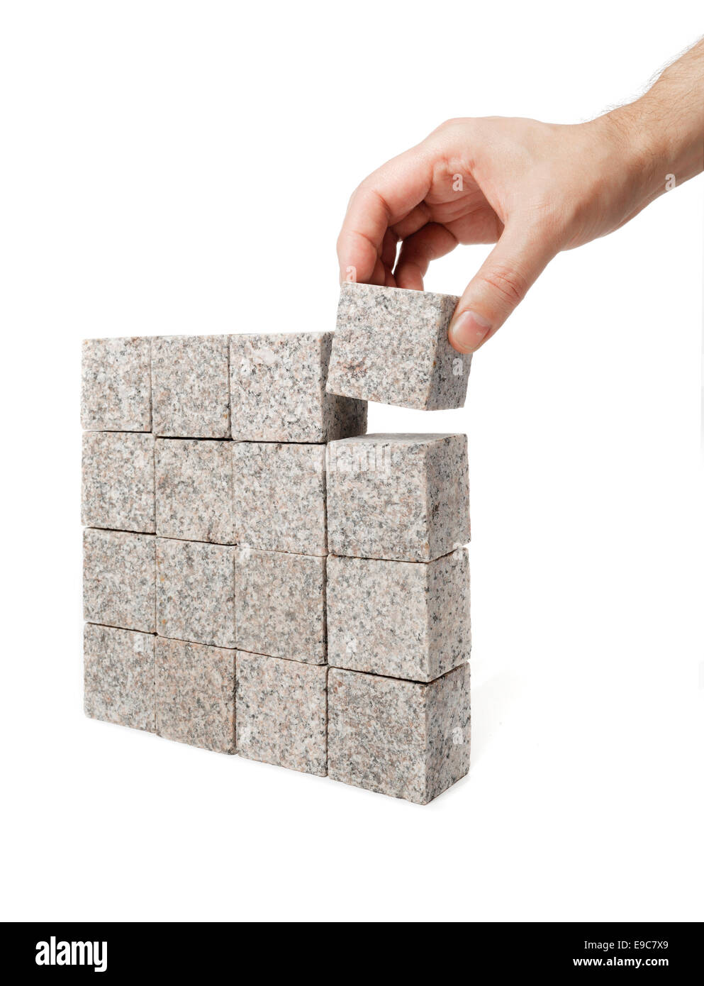 Man making a square shape of blocks made of granite rock. Stock Photo