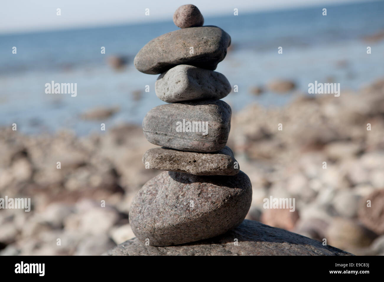 Stone tower on rocks, in the background of the rocky beach of the Baltic Sea Stock Photo