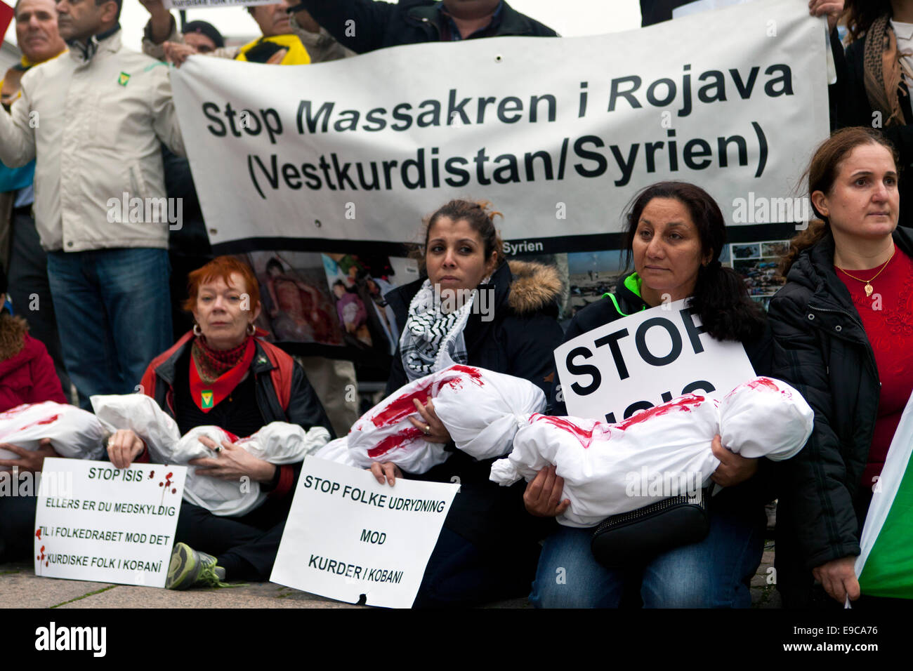 Copenhagen, Denmark. 24th Oct, 2014. Kurdish women sitting with blood stained body bags symbolizing the dead children in Kobani. The women are pictured as they participate in a solidarity demonstration at the parliament in Copenhagen which calls for They demand that Turkey opens its border for Kurdish fighters and emergency relief to Kobani Credit:  OJPHOTOS/Alamy Live News Stock Photo