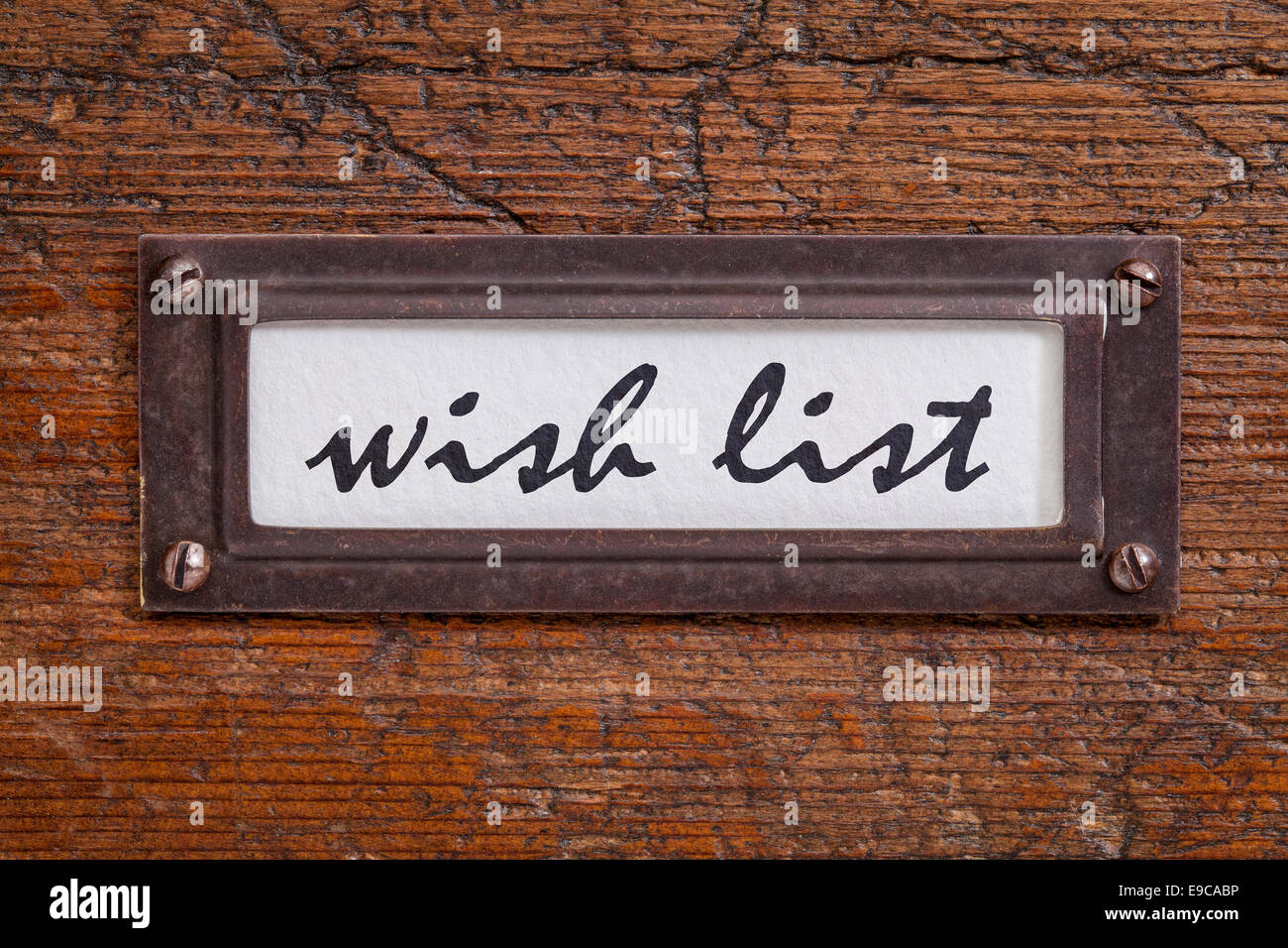 wish list - file cabinet label, bronze holder against grunge and scratched wood Stock Photo