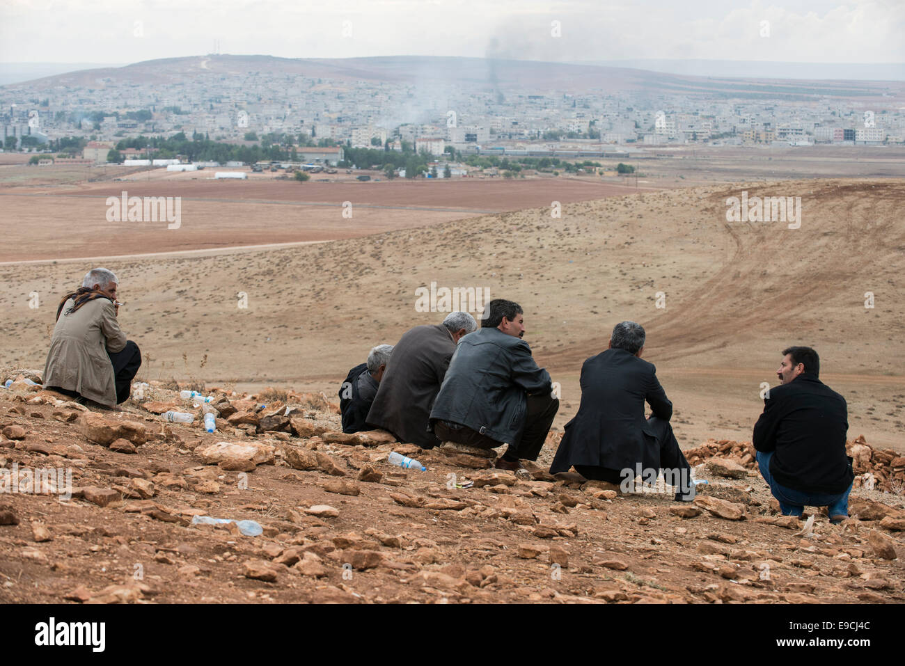 TURKEY, Suruc,10 km away from syrian border and from IS Islamic state besieged town Kobani, Kurds watch battle in Kobane from mountain, rising smoke after bombing by US airforce Stock Photo