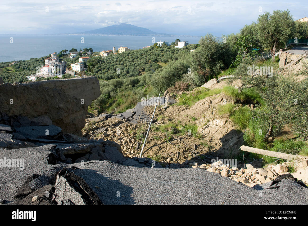 A flood damaged coastal road through olive groves and farmland, which has collapsed after heavy rain on the Bay of Naples near S Stock Photo