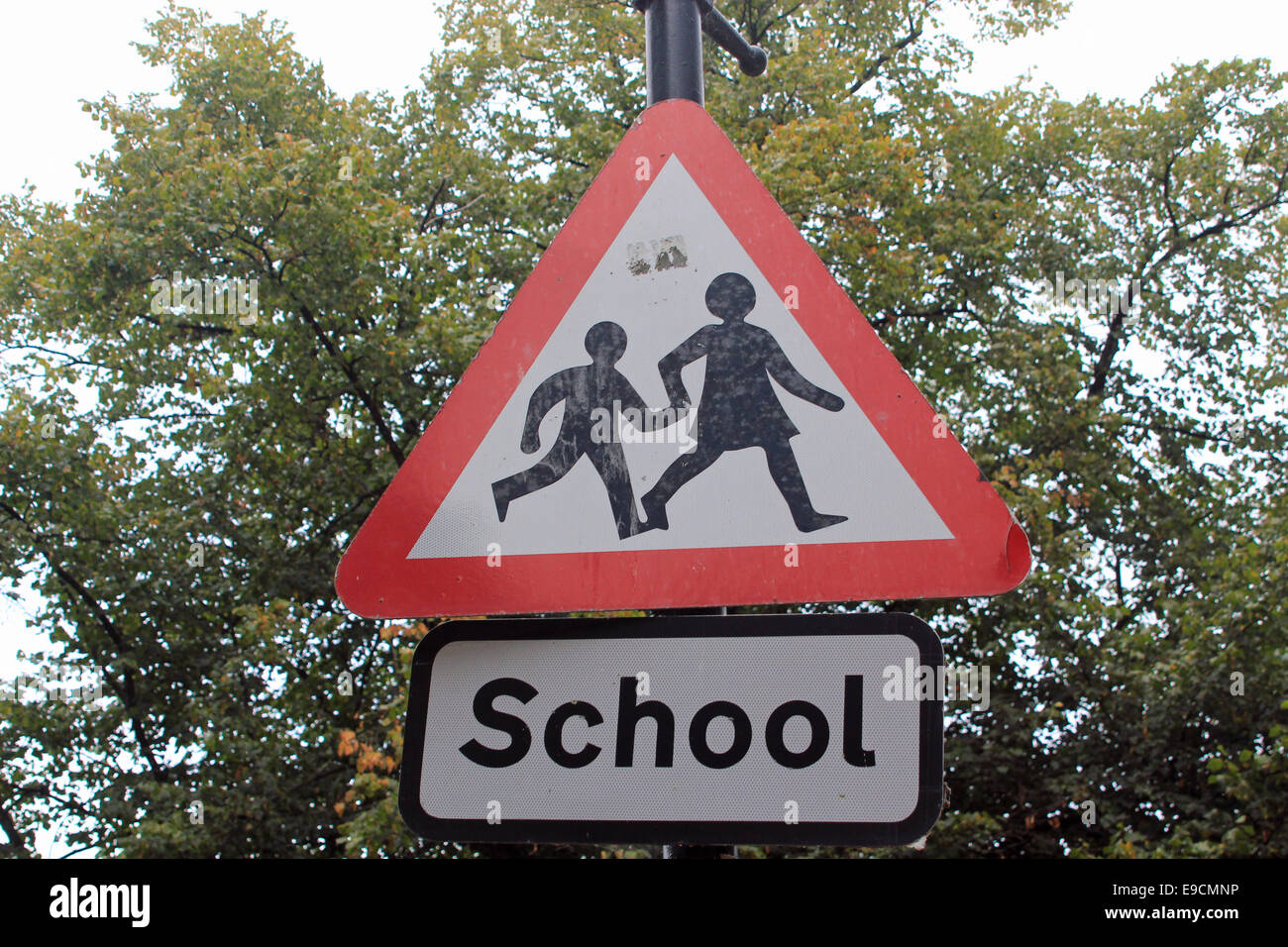 Close-up of a road sign warning of a school in the vicinity for motorists to slow down whilst driving Stock Photo