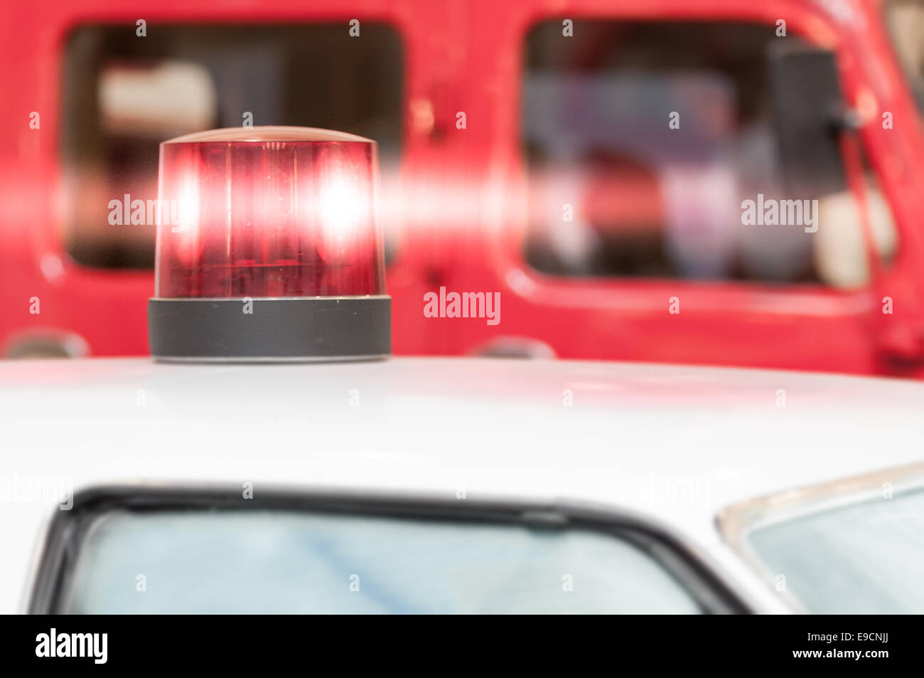 Detail of Flashing Red Siren Light on Roof of Emergency Vehicle Stock Photo