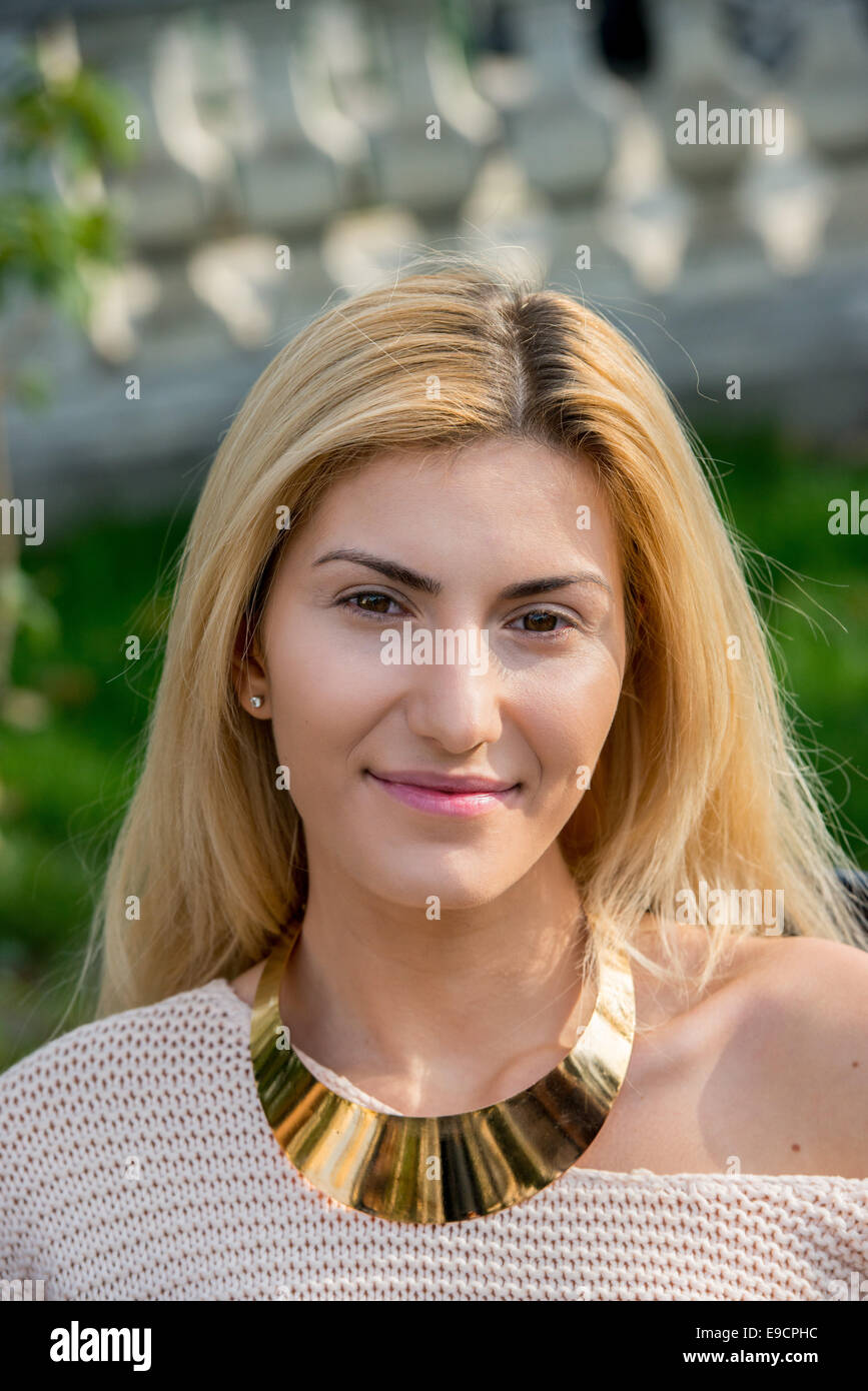 Blonde woman with gold necklace smiling Stock Photo