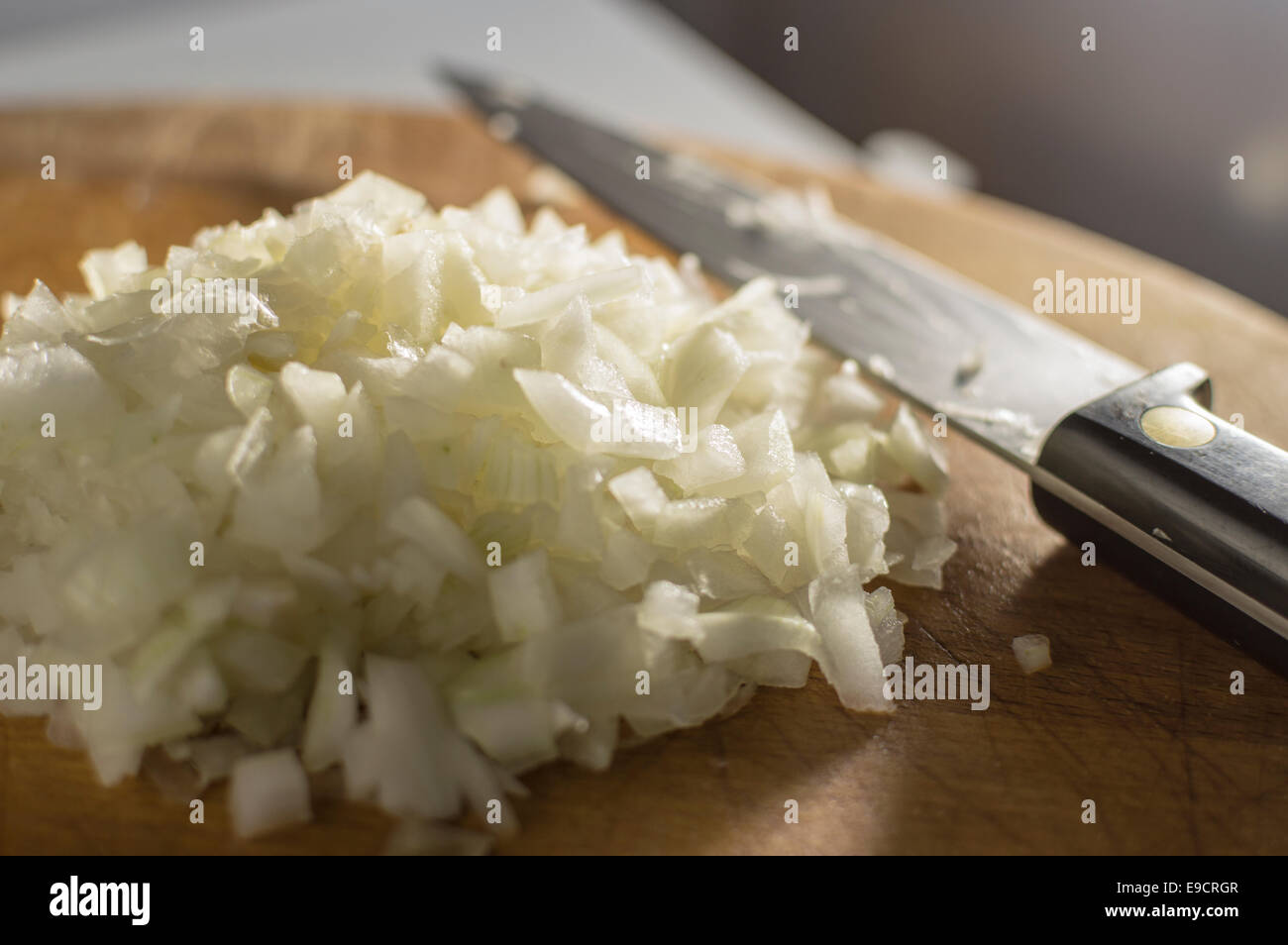 Mound of finely diced onion on a chopping board, knife to one side