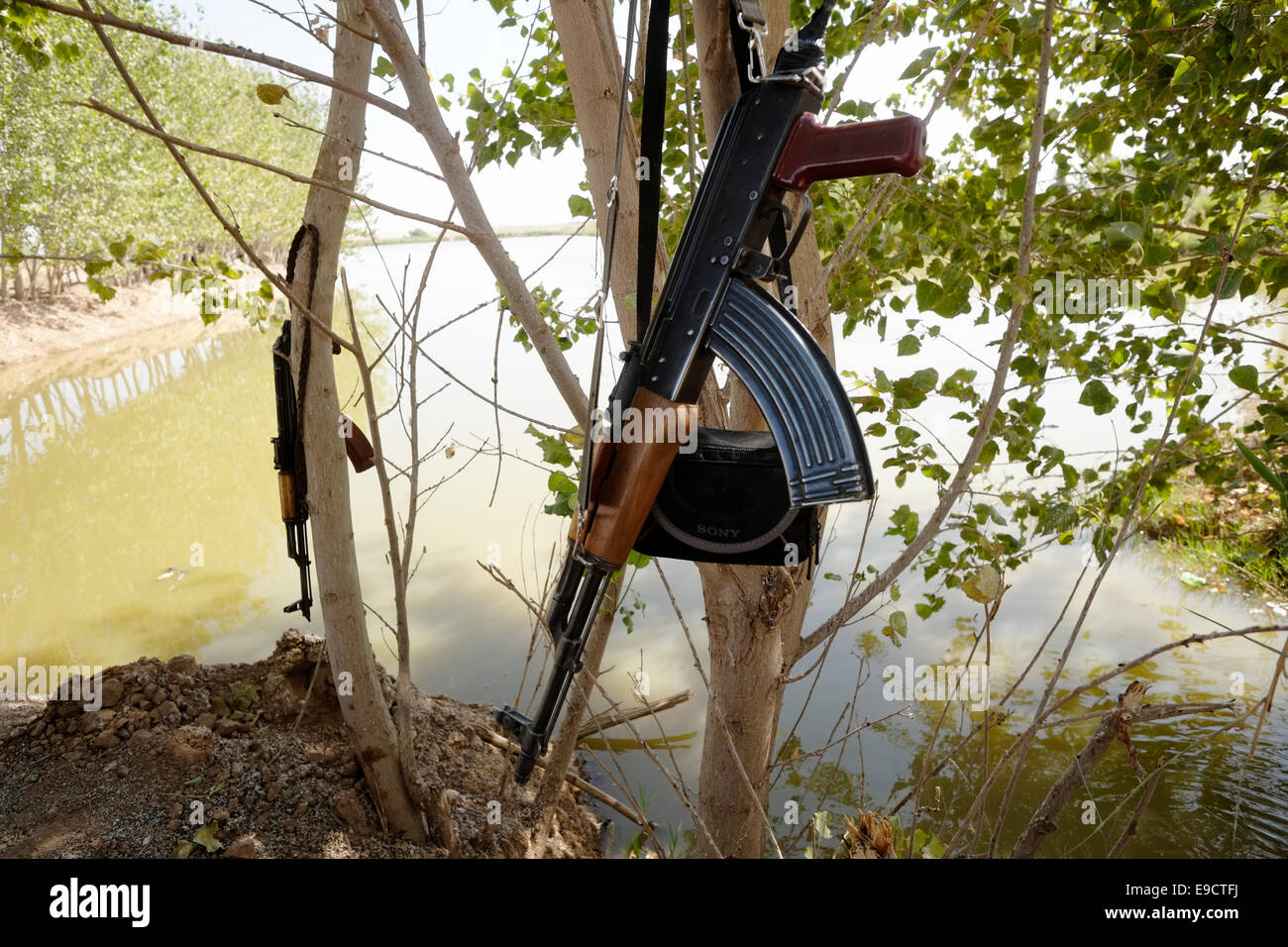 A Kalashnikov ak-47 gun rifle hanging on a tree in a front line outpost of the People's Defense Forces HPG the military wing of the Kurdistan Workers' Party PKK during a battle against ISIS or ISIL militants near the city of Kirkuk in northern Iraq Stock Photo