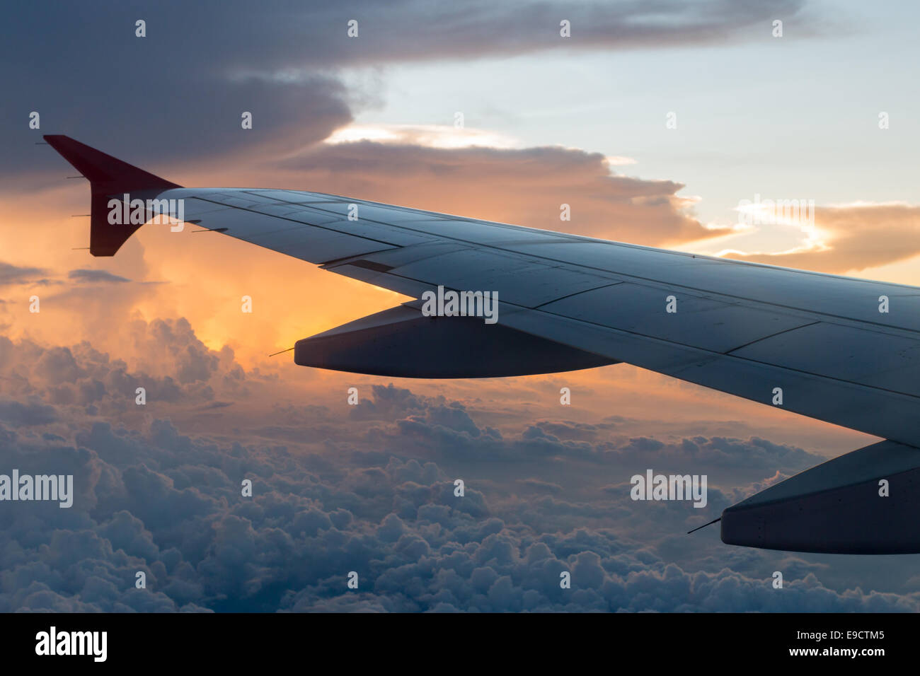 Wing of an airplane flying above the clouds Stock Photo - Alamy