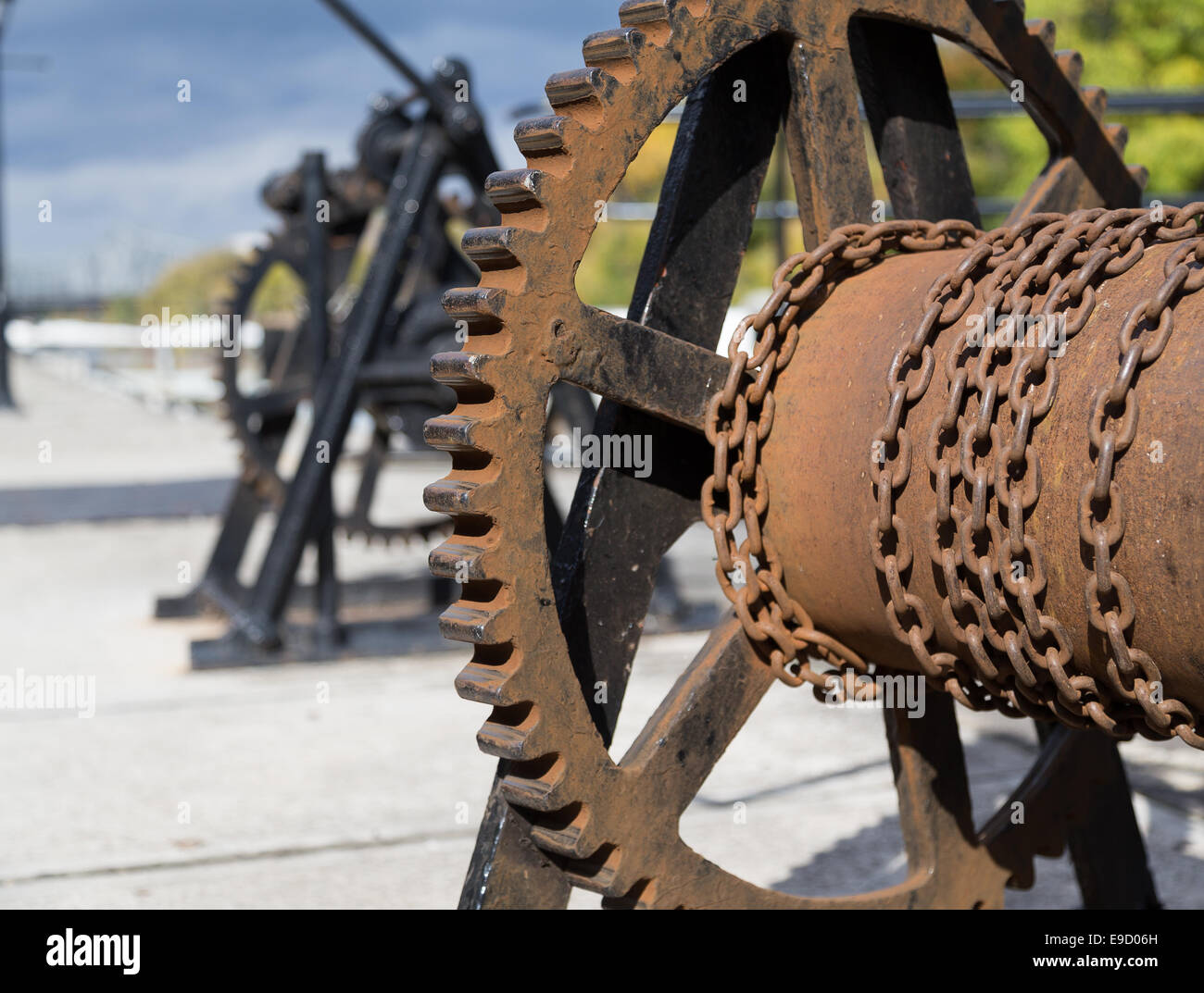 A closeup to a cog and chain contraption beside a canal Stock Photo