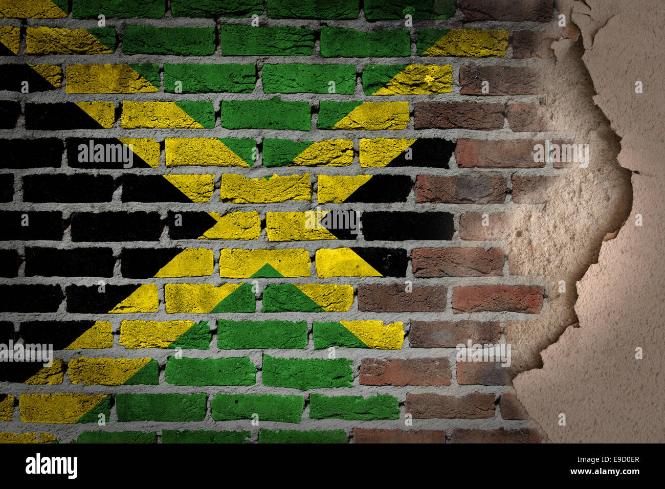 Dark brick wall texture with plaster - flag painted on wall - Jamaica Stock Photo