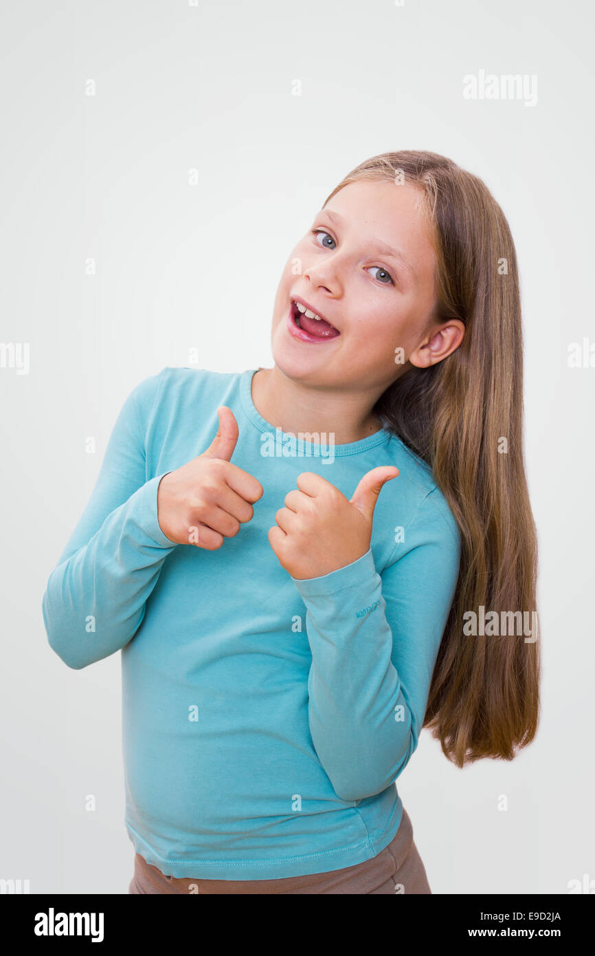 Little girl with long hair shows her thumbs Stock Photo