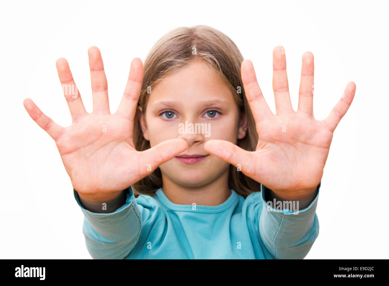 Little girl with long hair shows her ten fingers Stock Photo