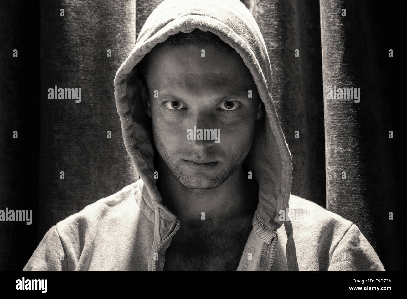 Black and white portrait of young Caucasian man in hood Stock Photo
