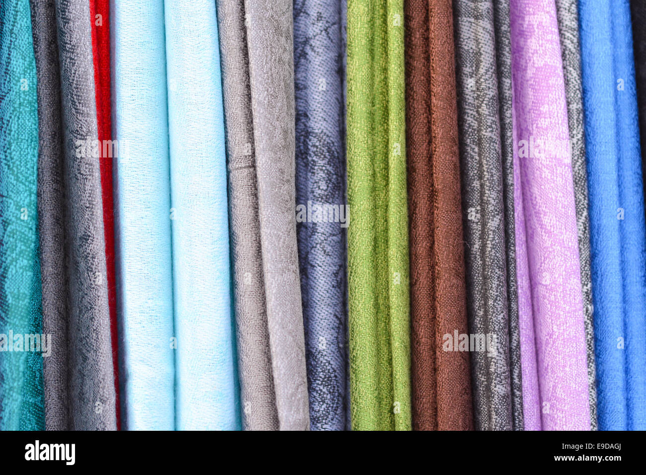 A selection of brightly coloured, textured fabric hanging vertically