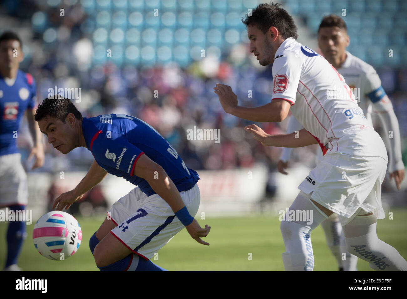Mexico City, Mexico. 25th Oct, 2014. Cruz Azul's Pablo Barrera (L) vies for the ball with Carlos Guzman of Morelia during their match of the MX League Opening Tournament at Azul Stadium in Mexico City, capital of Mexico, on Oct. 25, 2014. Credit:  Alejandro Ayala/Xinhua/Alamy Live News Stock Photo