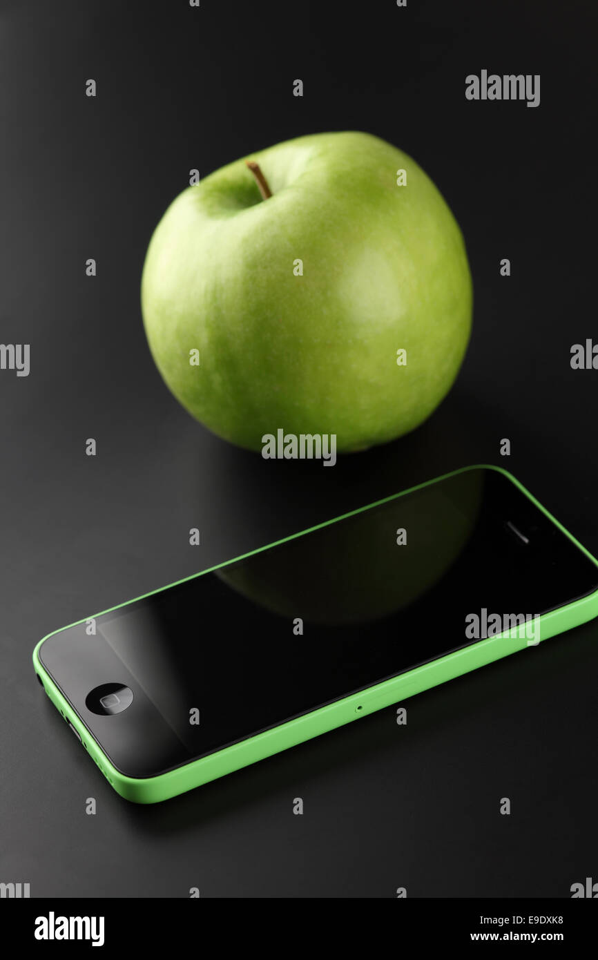 Tambov, Russian Federation - October 16, 2013 Apple iPhone 5C Green Color and green apple on black background . Studio shot. Stock Photo