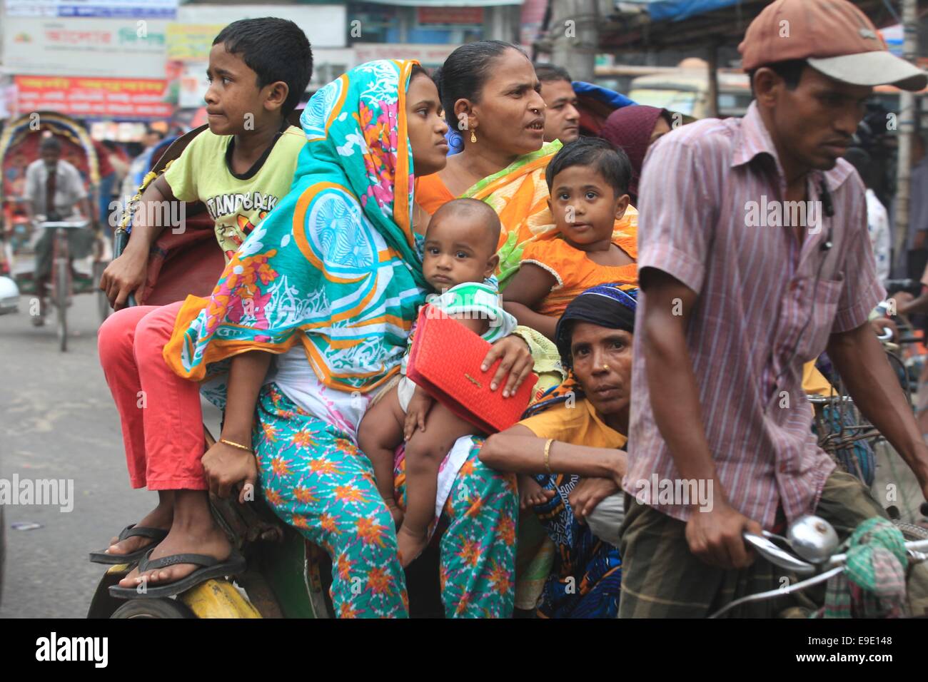 Oct. 26, 2014 - Dhaka, Dhaka, Bangladesh - Dhaka, Bangladesh: A family cross on the road during the Hortal day on 26 October in Dhaka, Bangladesh. During the Hortal day The daylong nationwide hartal, called by Sammilito Islami Dal, a coalition of Islamic parties, began at 6:00am on Sunday demanding sacked minister Abdul Latif Siddique's trial for his disparaging remarks about hajj and Tablig Jamaat. Â© Monirul Alam (Credit Image: © Monirul Alam/ZUMA Wire) Stock Photo